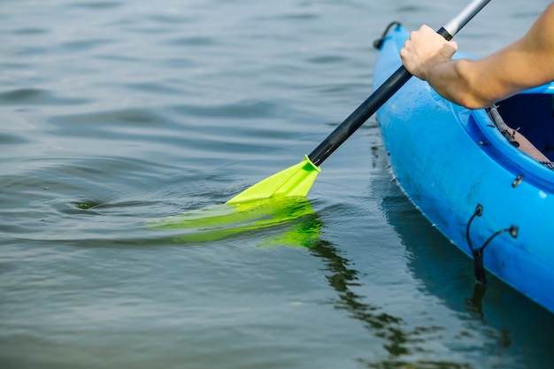 Free photo man paddling a kayak over lake