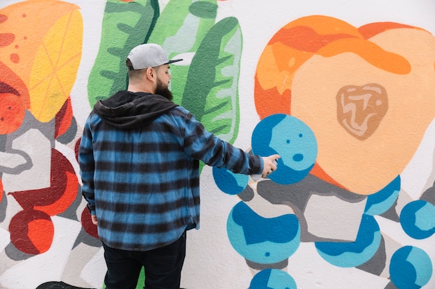 Man painting graffiti on wall