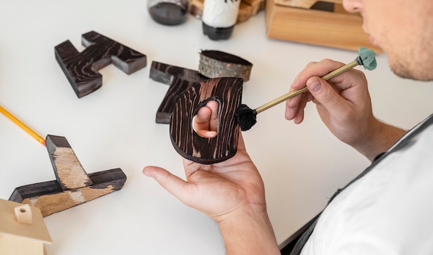 Man painting wooden letters