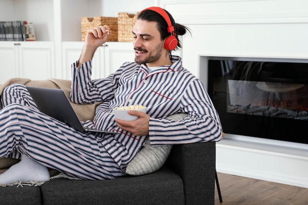 Man in pajamas eating popcorn
