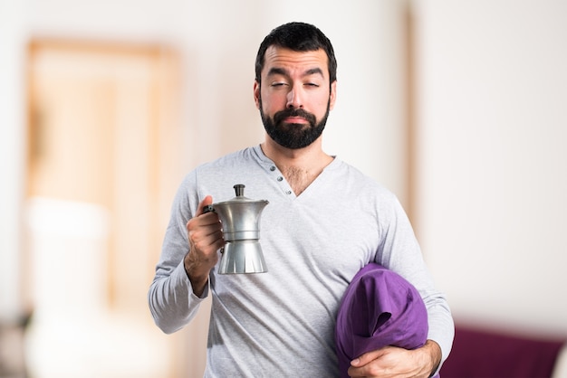 Man in pajamas holding a coffee pot