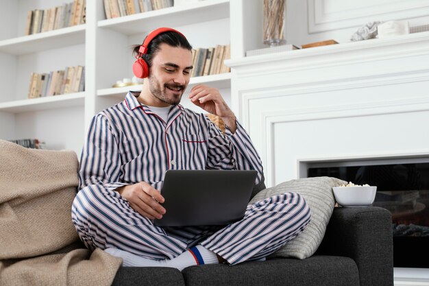 Man in pajamas spending fun time on laptop