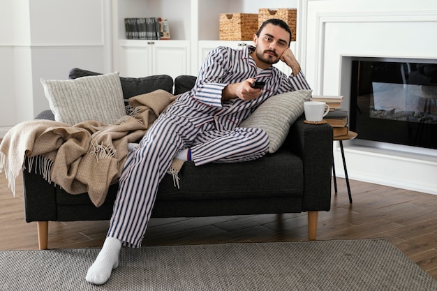 Free photo man in pajamas watching tv