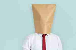 Free photo man paper bag cover face ashamed portrait concept