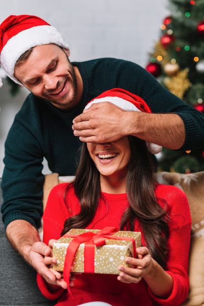 Man in party hat closing eyes to surprised woman