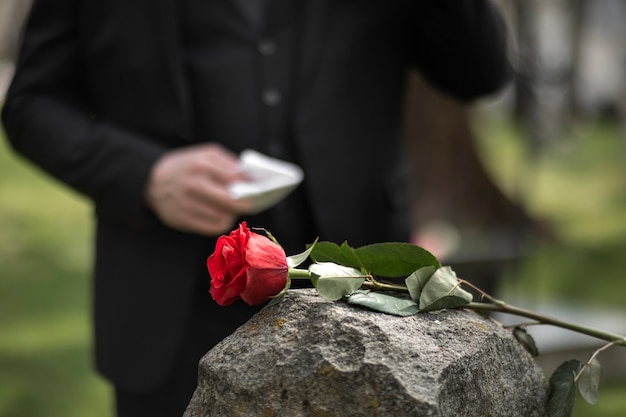 Бесплатное фото Мужчина отдает дань уважения надгробной плите на кладбище