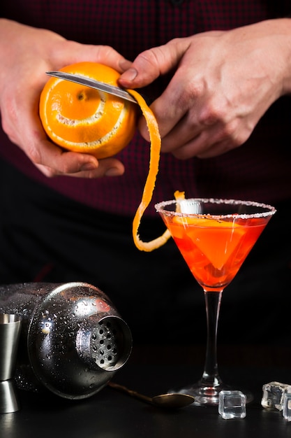 Человек пилинг апельсин для коктейля