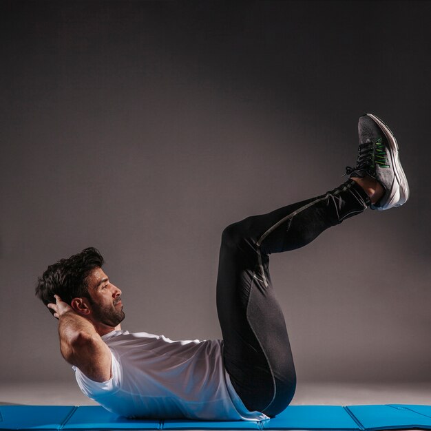 Free photo man performing abdominal crunches