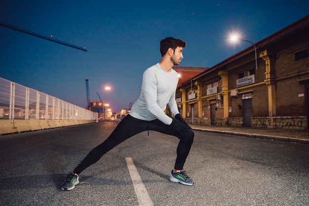 Free photo man performing lunges on road