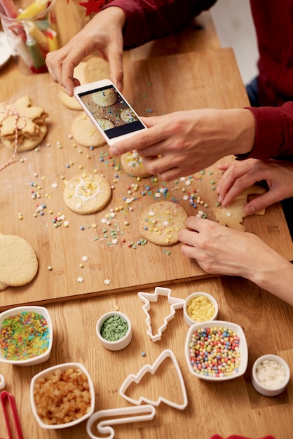 Free photo man photographing his christmas cookies