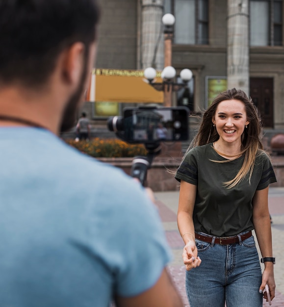 Free photo man photographing woman with phone