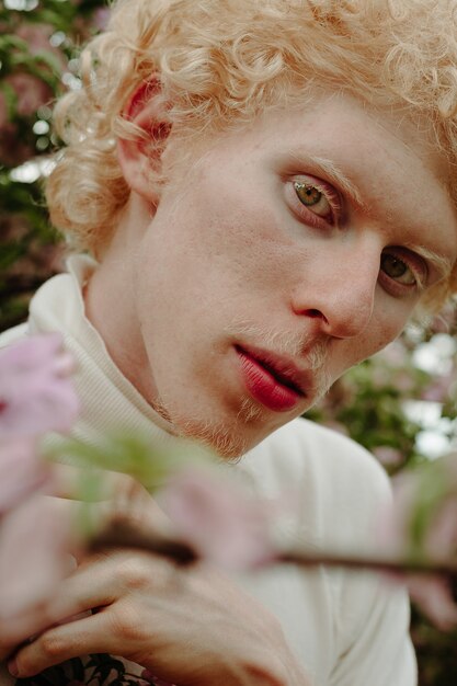 Man behind Pink Flowers posing in the park