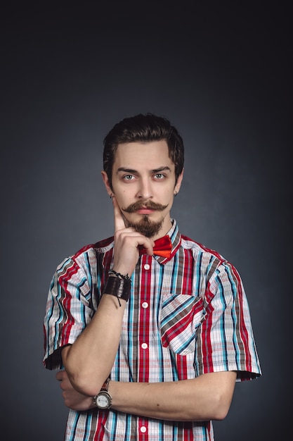 Man in plaid shirt and bow tie in the studio