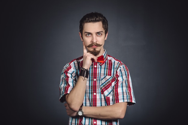 Man in plaid shirt and bow tie in the studio