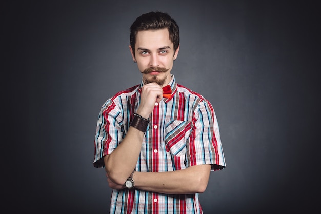 Man in plaid shirt and bow tie in the studio