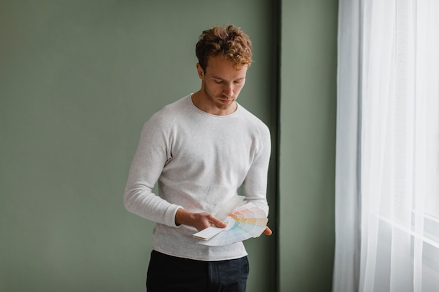 Man planning to redecorate the house using paint palette