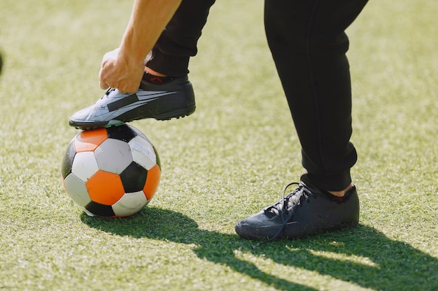 무료 사진 남자는 공원에서 socerl을 재생합니다. 미니 축구 토너먼트. 검은 sportsuits에있는 남자.