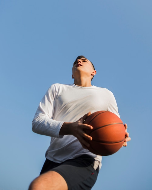 Foto gratuita uomo che gioca a basket angolo basso