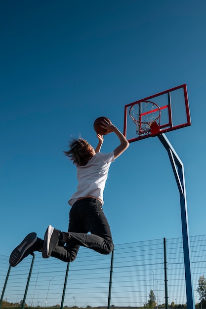 屋外でバスケットボールをしている男ローアングル