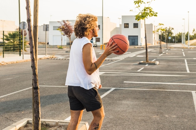 通りにバスケットボールをしている男