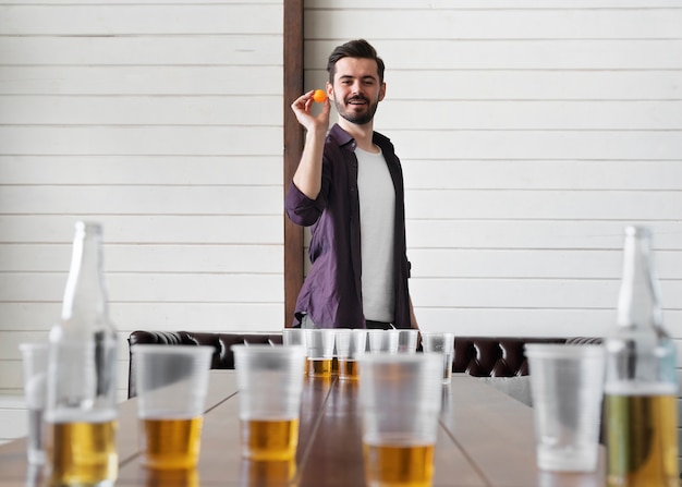 Uomo che gioca a beer pong a una festa al coperto