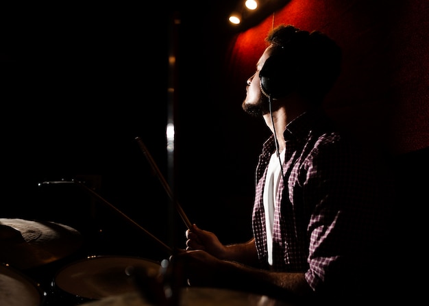 Человек играет на барабанах в темноте