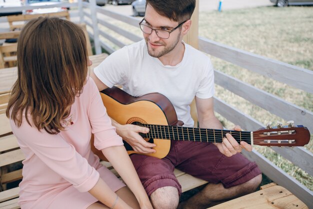 남자가 그의 여자 친구를 위해 기타를 연주