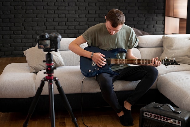 Free photo man playing guitar at home