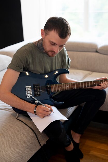 Man playing guitar at home