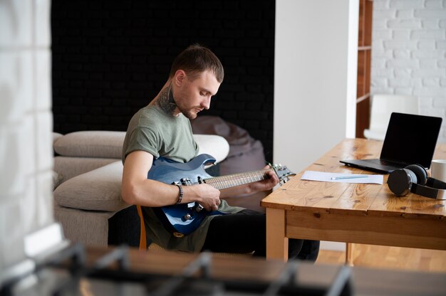 Man playing guitar at home