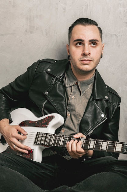 man playing guitar and looking away