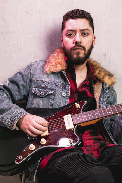 Man playing guitar and looking at photographer