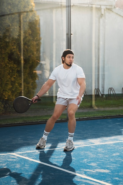 Free photo man playing paddle tennis full shot