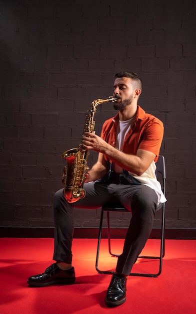 Man playing saxophone while sitting down