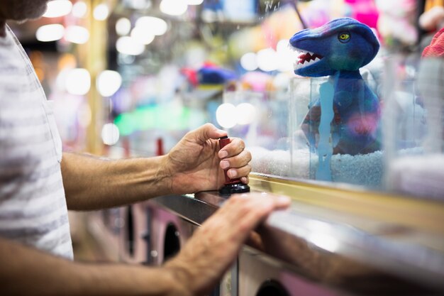 Man playing tow claw machine