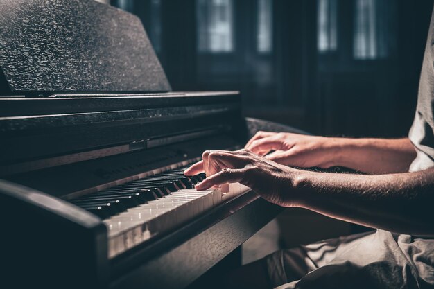 A man plays an electronic piano in a dark room