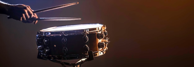 A man plays a snare drum on a dark background copy space