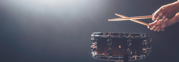 Free photo a man plays a snare drum on a dark background copy space