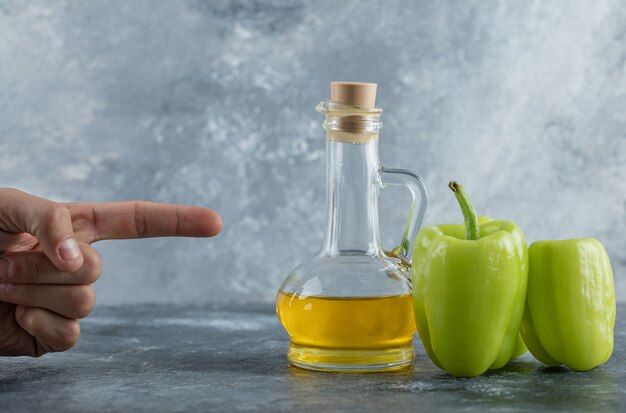 Man pointing finger to the pepper and oil. High quality photo