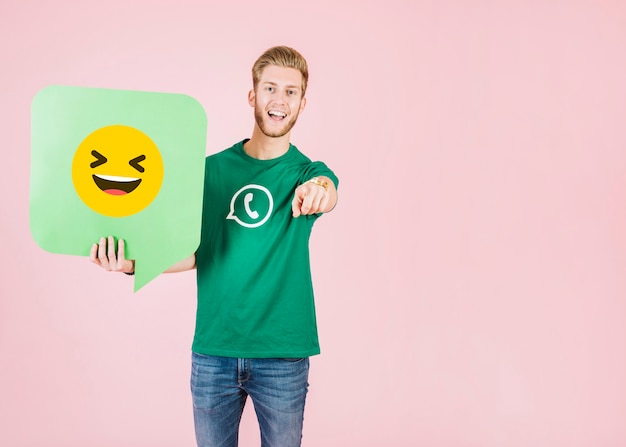 Man pointing his finger while holding speech bubble with smiling emoji