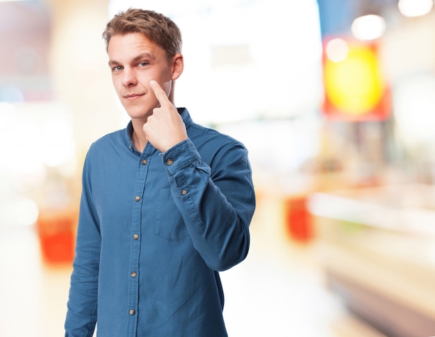 Man pointing his own one eye