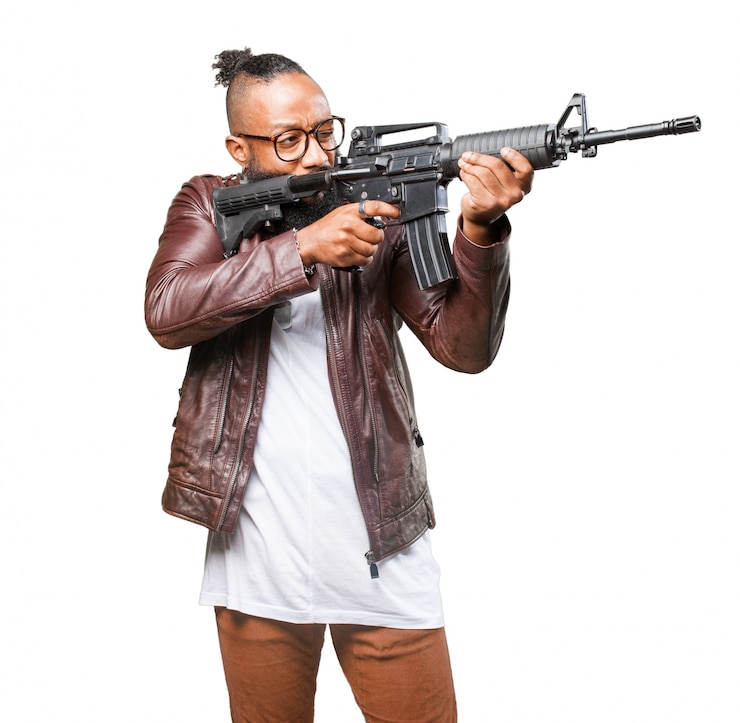 Free Photo man pointing to his side with machine gun