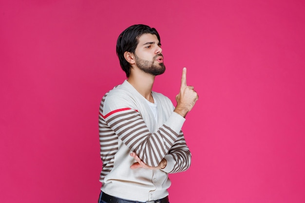 Uomo che indica qualcosa o che presenta qualcuno.