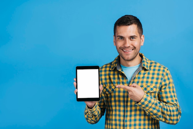 Foto gratuita uomo che punta a un tablet mock-up