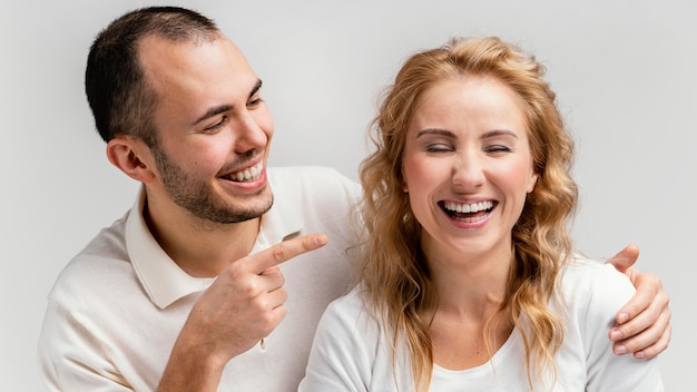 Man pointing at woman laughing