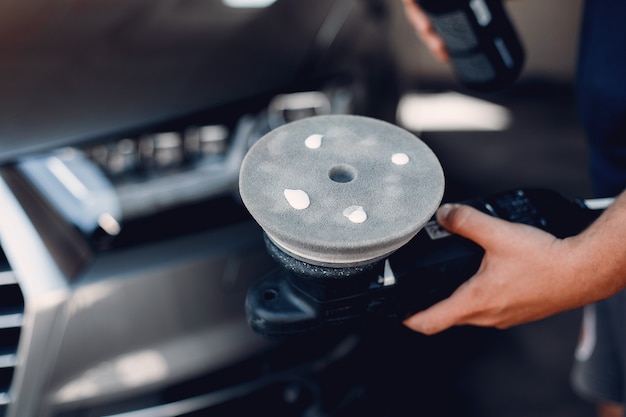 Foto gratuita l'uomo lucidare un'auto in un garage