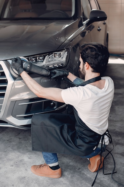 Man polish a car in a garage