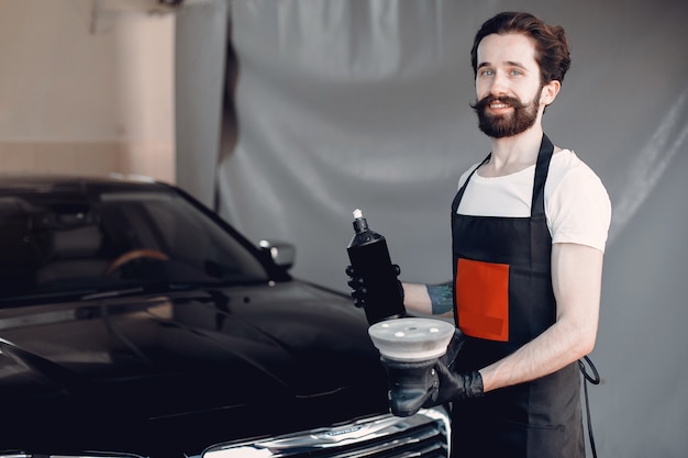 Free photo man polish a car in a garage