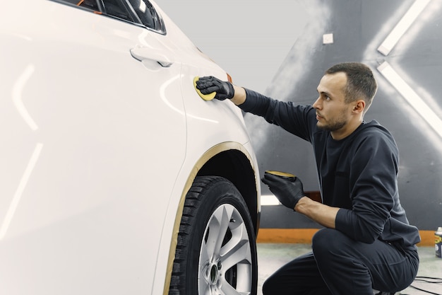 Man polish a car in a garage