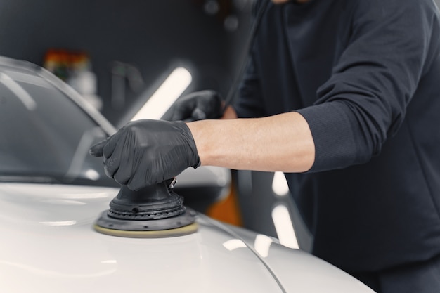 Man polish a car in a garage